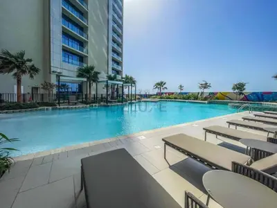 a large swimming pool in a building with tables and chairs at Steps from Dubai Water Canal 2BR, Near Safa Park & SZR, Easy Downtown Access, Aykon City 2 Tower C, Business Bay by Deluxe Holiday Homes in Dubai