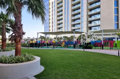 a park with palm trees and a large building at Steps from Dubai Water Canal 2BR, Near Safa Park & SZR, Easy Downtown Access, Aykon City 2 Tower C, Business Bay by Deluxe Holiday Homes in Dubai