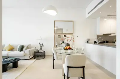 a kitchen and a living room with a table and chairs at Stunning 1BR Canal Front Residence near Downtown in Dubai