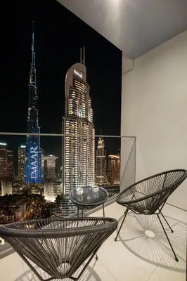 a room with two tables and a view of the city at Burj Khalifa & Fountain Balcony Views, Pool & Gym in Dubai