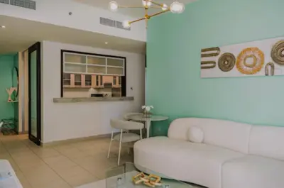 a living room with a white couch and a table at Burj View 1BR Pool,Gym,Sauna,Dubai Mall in Dubai
