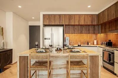 a kitchen with a large wooden table with two chairs at Seraya Residences at Marina Vista, Emaar Beachfront in Dubai