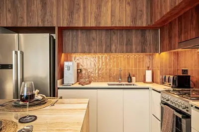a kitchen with white cabinets and wooden walls at Seraya Residences at Marina Vista, Emaar Beachfront in Dubai