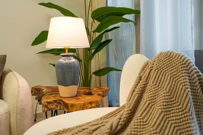 a blanket on a chair next to a table with a lamp at Guest Favorite - 2BR Apartment 57th Floor Close to Downtown in Dubai