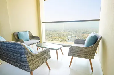 a room with two chairs and a table and a large window at Guest Favorite - 2BR Apartment 57th Floor Close to Downtown in Dubai