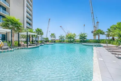 a swimming pool at a resort with trees and a building at Guest Favorite - Premium 3BR with Skyline Views at Floor 50 in Dubai