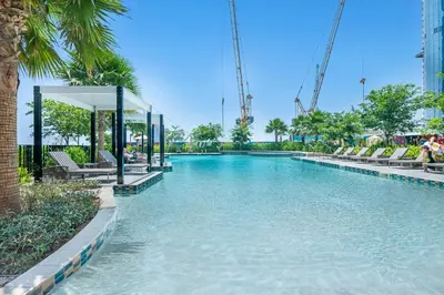 a swimming pool with chairs in a resort at Guest Favorite - Premium 3BR with Skyline Views at Floor 50 in Dubai