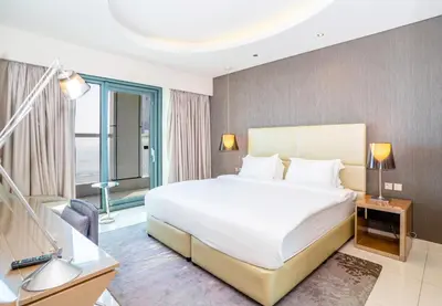 a bedroom with a large white bed and a window at Paramount Tower 1 BR, Hollywood Style Stay in Dubai