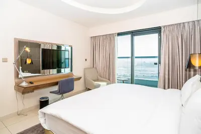 a hotel room with a bed and a desk and a television at Paramount Tower 1 BR, Hollywood Style Stay in Dubai
