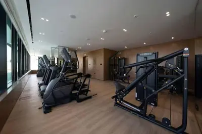 a gym with treadmills and ellipticals in a room at Guest Favorite - Minimalist 1BR Escape with Balcony in the Heart of JVC in Dubai