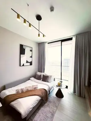 a bedroom with a large bed and a large window at Guest Favorite - Minimalist 1BR Escape with Balcony in the Heart of JVC in Dubai
