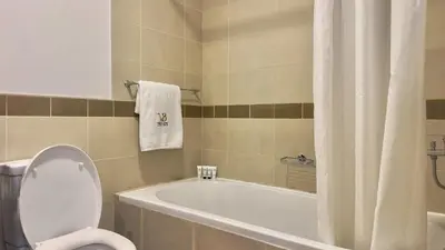 a bathroom with a tub and a toilet and a sink at Guest Favorite - Calm and Classy 1BR on High Floor - Walk to Dubai Mall in Dubai