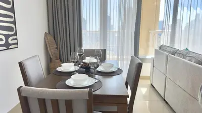 a dining room with a table and chairs with wine glasses at Guest Favorite - Calm and Classy 1BR on High Floor - Walk to Dubai Mall in Dubai