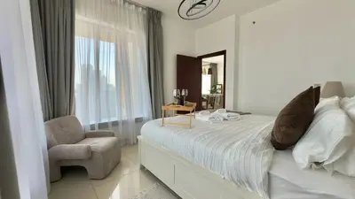 a bedroom with a bed and a chair and a mirror at Guest Favorite - Calm and Classy 1BR on High Floor - Walk to Dubai Mall in Dubai