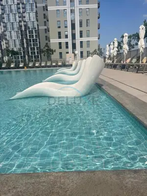 a white slide in a pool of water at Steps from Dubai Hills Mall, Surrounded by Top-Tier Amenities, and close to Dubai Hills Park and Golf Club, Socio Tower 1, Dubai Hills by Deluxe Holiday Homes in Dubai