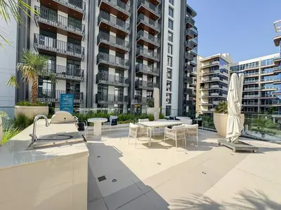 a patio with tables and chairs in front of a building at Premium 2BR with Pool, Gym & Lifestyle Amenities in Dubai