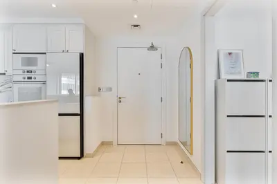 a kitchen with white appliances and a refrigerator at Upmarket - 1BR - Canal View - 9 MIN Dubai Mall in Dubai