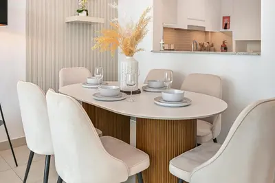 a dining room with a white table and chairs at Golden Stays - Luxury 2BR I Burj Views & Direct Dubai Mall Access in Dubai