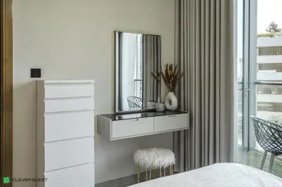 a bedroom with a dresser and a mirror at Clever Guest 032 Hartland Waves in Dubai