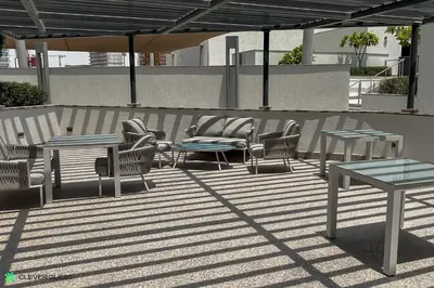 a group of tables and chairs on a patio at Clever Guest 032 Hartland Waves in Dubai