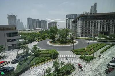 a street in a city with cars and a park at Clever Guest 032 Hartland Waves in Dubai