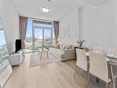 a living room with a couch and a table at Bright 1 Bedroom Apartment with JVC open view in Dubai