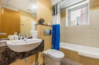 a bathroom with a sink and a toilet and a tub at Metro-Accessible 2BR, Easy Reach to Marina Mall and JBR Beach, Featuring Stunning SZR & City Views, Marina Diamond 2, Dubai Marina by Deluxe Holiday Homes in Dubai