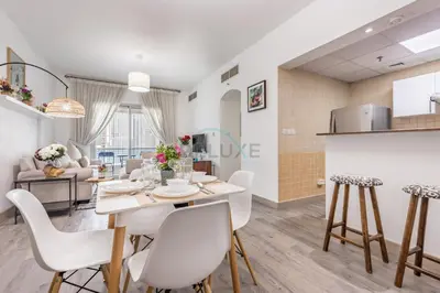 a dining room and living room with a table and chairs at Metro-Accessible 2BR, Easy Reach to Marina Mall and JBR Beach, Featuring Stunning SZR & City Views, Marina Diamond 2, Dubai Marina by Deluxe Holiday Homes in Dubai