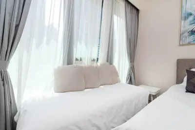 a bedroom with two white beds and a window at Guest Favorite - Modern and Upgraded 2BR Heart of Downtown in Dubai