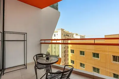 a balcony with a table and chairs and a window at Sunny Studio with Pool, Near Silicon Central Mall in Dubai