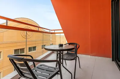 a balcony with a table and chairs on a building at Sunny Studio with Pool, Near Silicon Central Mall in Dubai