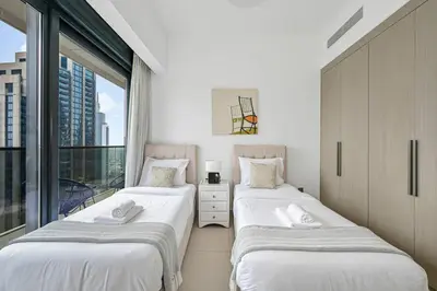 two beds in a room with a window at Stylish 2BR Downtown Dubai in Dubai