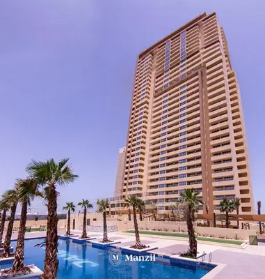 a large building with palm trees in front of a pool at Central 1BHK in JVC w Pool near Dubai Sports City in Dubai