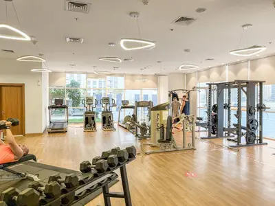 a gym with lots of treadmills and machines at FIRST CLASS 1BR Stylish Vibe in Dubai
