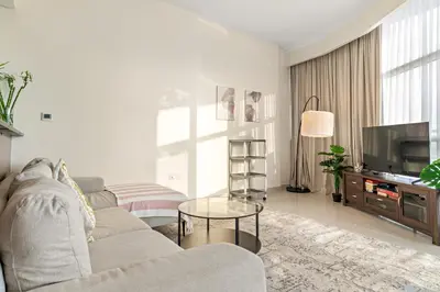 a living room with a couch and a tv at FIRST CLASS 1BR Stylish Vibe in Dubai