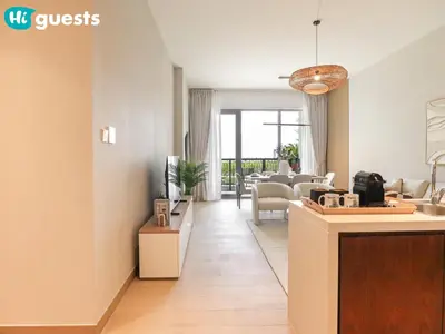 a living room with a kitchen and a living room with a table at HiGuests - Lavish 2BR Apt with Private Beach Access in Dubai