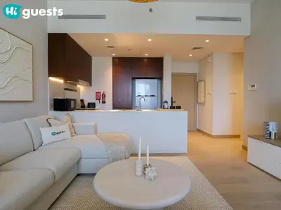 a living room with a couch and a table at HiGuests - Lavish 2BR Apt with Private Beach Access in Dubai