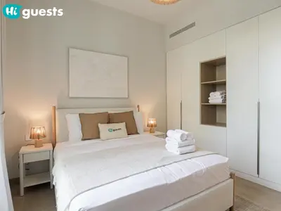 a bedroom with a large white bed with two lamps at HiGuests - Lavish 2BR Apt with Private Beach Access in Dubai