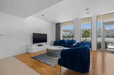 a living room with blue chairs and a tv at Bluewater Residence 6- Spacious Outlet in Dubai