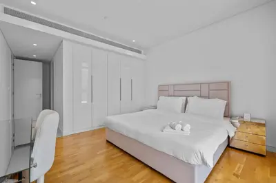 a white bedroom with a white bed and a chair at Bluewater Residence 6- Spacious Outlet in Dubai