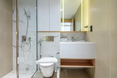 a bathroom with a shower and a toilet and a sink at Brand New 1 Bedroom in AURA by Grovy, JVC in Dubai