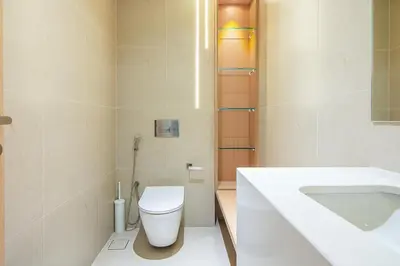 a bathroom with a white toilet and a sink at Brand New 1 Bedroom in AURA by Grovy, JVC in Dubai