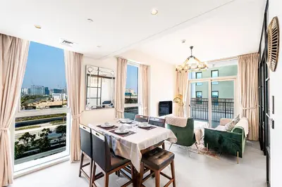 a dining room with a table and a large window at Escape 24 Lux 2BR Collective Dubai Hills in Dubai