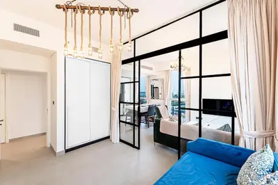 a living room with a blue couch and large windows at Escape 24 Lux 2BR Collective Dubai Hills in Dubai