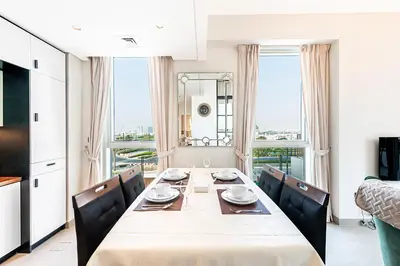 a dining room with a table and chairs with a view at Escape 24 Lux 2BR Collective Dubai Hills in Dubai