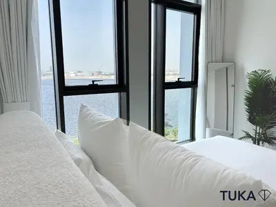a bed with white pillows in a room with windows at Canal View - 2-BHK - Creek Harbour - Central - Lux in Dubai