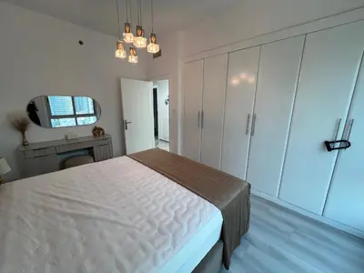 a bedroom with a bed and a dresser and a tv at Italian-Style 2BR - Near Beach, Metro and Mall in Dubai