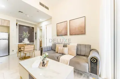 a living room with a couch and a table at Conveniently Located Minutes from Dubai Hills Mall, Park, Golf Club, and Essential City Landmarks 1BR with Premium Facilities, Damac Hills Golf Vita A, Damac Hills 1 by Deluxe Holiday Homes in Dubai