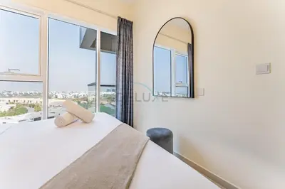 a bedroom with a bed and a large window at Conveniently Located Minutes from Dubai Hills Mall, Park, Golf Club, and Essential City Landmarks 1BR with Premium Facilities, Damac Hills Golf Vita A, Damac Hills 1 by Deluxe Holiday Homes in Dubai