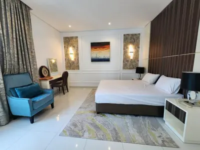 a hotel room with a bed and a chair at Stylish Suites 1 Br Business Bay in Dubai